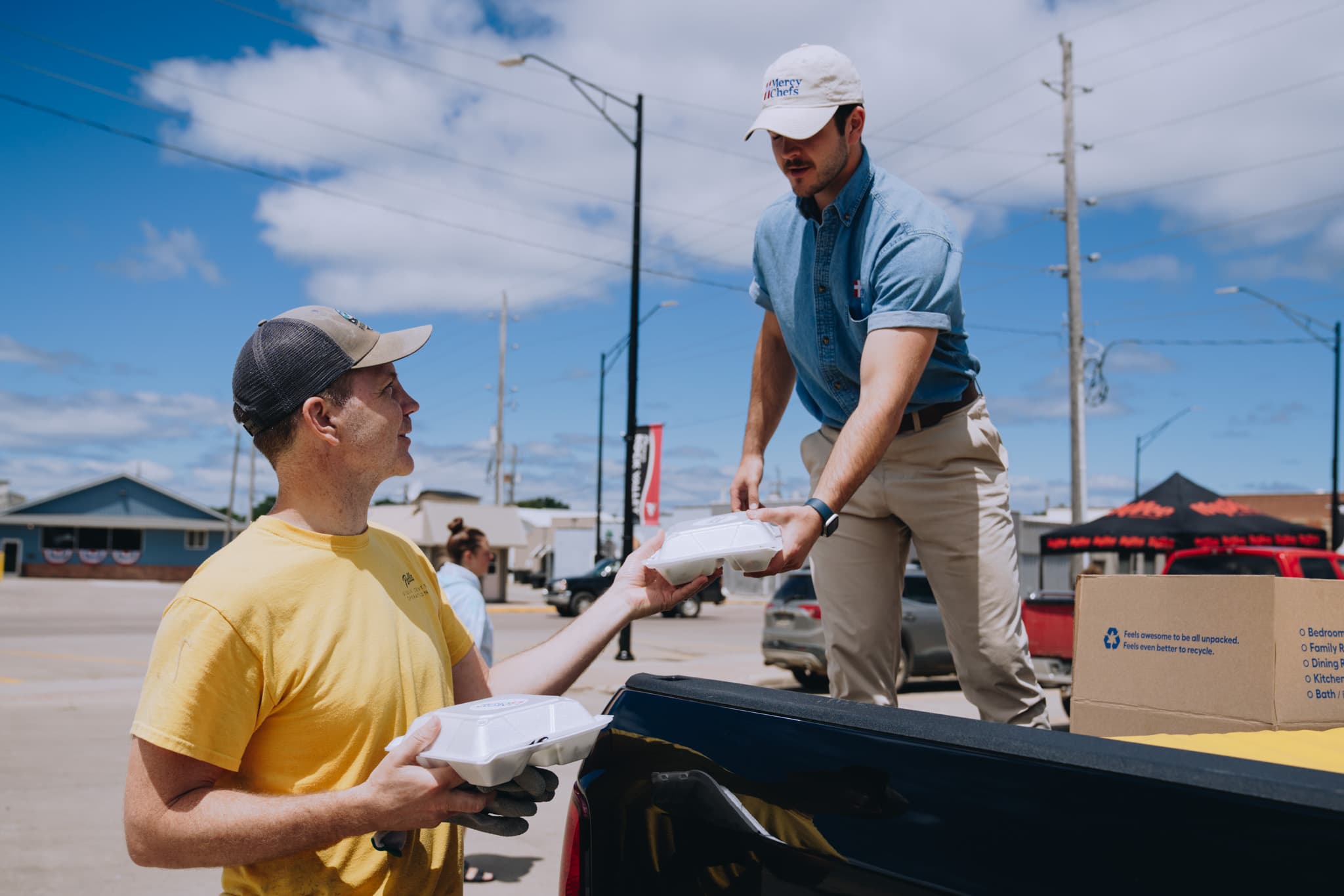 Man distributing meals from back up truck
